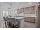 Bright kitchen featuring a central island with seating, pendant lights, and modern appliances at 25 Basil Ct, Franklinton, NC 27525