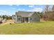 Back exterior view of a light green home featuring a screened-in porch and spacious lawn at 25 Basil Ct, Franklinton, NC 27525