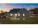 View of a dark siding home featuring a screened porch and well-maintained lawn at dusk at 25 Basil Ct, Franklinton, NC 27525