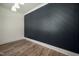Stylish room featuring plank flooring and a contemporary black accent wall with a herringbone pattern at 1226 Red Cedar Ct, Youngsville, NC 27596
