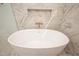 Elegant bathroom showcases a freestanding tub with bronze fixtures and marble-look tile surround at 1226 Red Cedar Ct, Youngsville, NC 27596