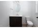 Modern half bathroom featuring a stylish vanity with dark wood cabinets, light walls, and a decorative mirror at 1226 Red Cedar Ct, Youngsville, NC 27596