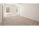 Bright, carpeted bedroom featuring two windows for natural light and modern base trim at 1226 Red Cedar Ct, Youngsville, NC 27596