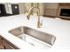 Close-up of a modern kitchen sink with a white countertop and a stylish gold faucet at 1226 Red Cedar Ct, Youngsville, NC 27596