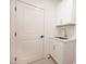 Well-lit laundry room with white cabinets and countertops at 1226 Red Cedar Ct, Youngsville, NC 27596