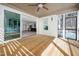 Covered patio offers a serene view of the snowy woods, complete with wood flooring, a ceiling fan, and ample light at 1226 Red Cedar Ct, Youngsville, NC 27596