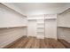 Spacious walk-in closet with wood floors, and wooden shelves and rods for ample storage at 1226 Red Cedar Ct, Youngsville, NC 27596