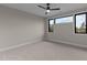 Spacious bedroom with neutral carpet, trim, black framed windows and a ceiling fan at 30 Hartwood Ln, Youngsville, NC 27596