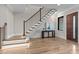 Elegant foyer with hardwood floors, staircase with black metal railings, and stone wall accents at 30 Hartwood Ln, Youngsville, NC 27596