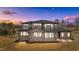 A two-story home is illuminated at twilight, highlighting its screened porch and meticulously maintained lawn at 30 Hartwood Ln, Youngsville, NC 27596