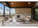 Inviting screened-in porch features a stone fireplace, vaulted ceiling, and stylish outdoor furniture at 30 Hartwood Ln, Youngsville, NC 27596