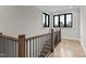 Bright staircase landing with hardwood floors, black metal railing, and natural light from the window at 30 Hartwood Ln, Youngsville, NC 27596