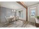 Bright dining room with gray wall paneling, hardwood floors, and a large window at 115 Beauview Way, Zebulon, NC 27597