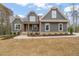 Two-story house with gray siding, stone accents, and a covered porch at 115 Beauview Way, Zebulon, NC 27597