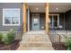 Charming front porch with stone steps, wooden posts, and a light blue door at 115 Beauview Way, Zebulon, NC 27597