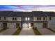 Townhomes with driveways and garages in the evening light with black roofs and neutral siding at 937 Alma Railway Dr # 555, Wake Forest, NC 27587