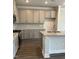 Bright kitchen features gray cabinets, stainless steel appliances, granite countertops, and a center island with sink at 937 Alma Railway Dr # 555, Wake Forest, NC 27587