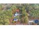 An aerial view of a charming home nestled among trees, with a well-maintained lawn and separate outbuilding at 143 Rawhide Dr, Louisburg, NC 27549