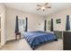 Cozy bedroom with a comfortable bed, ceiling fan, and two bright windows at 143 Rawhide Dr, Louisburg, NC 27549