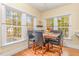Bright dining area with a wooden table, seating for four, and three large windows at 143 Rawhide Dr, Louisburg, NC 27549