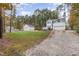 Exterior view of a home with a detached garage, long driveway and a sprawling lawn at 143 Rawhide Dr, Louisburg, NC 27549