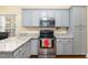 Modern kitchen features stainless steel appliances, granite countertops and light gray cabinetry at 143 Rawhide Dr, Louisburg, NC 27549