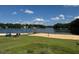 Lake view featuring a sandy beach with volleyball net and water views under a bright sky with fluffy clouds at 143 Rawhide Dr, Louisburg, NC 27549