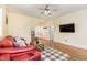 Comfortable living room with wood floors, ceiling fan, and red leather sofa at 143 Rawhide Dr, Louisburg, NC 27549