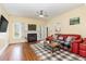 Inviting living room with fireplace, wood floors, and a comfortable red leather sofa at 143 Rawhide Dr, Louisburg, NC 27549