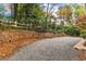 Gravel driveway and stone retaining wall, surrounded by mature trees at 2600 Wade Ave, Raleigh, NC 27607