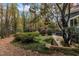 Landscaped yard with trees and foliage, a path and stone wall at 2600 Wade Ave, Raleigh, NC 27607