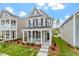 Charming two-story home featuring gray siding, black shutters, and a welcoming front porch with white columns at 276 White Oak Garden Way # 210, Garner, NC 27529