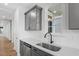 Modern kitchen boasts stainless steel sink, grey cabinets, white subway tile backsplash, and bright natural light at 276 White Oak Garden Way # 210, Garner, NC 27529