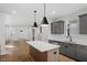 Modern kitchen featuring a center island, gray cabinets, stainless steel appliances, and an open layout to the living area at 276 White Oak Garden Way # 210, Garner, NC 27529