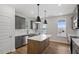 Modern kitchen features grey cabinets, white countertops, stainless steel appliances, and an island with pendant lighting at 276 White Oak Garden Way # 210, Garner, NC 27529