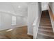 Spacious living area with elegant tray ceiling, hardwood floors, and staircase with carpeted steps at 276 White Oak Garden Way # 210, Garner, NC 27529