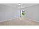 A bright bedroom with a neutral carpet and one window providing a view of the lawn and the neighborhood at 604 Spellbrook Rd, Zebulon, NC 27597