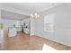 Elegant dining room with a modern chandelier, wainscoting, and an open view to the kitchen at 604 Spellbrook Rd, Zebulon, NC 27597