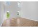 Open living room with high ceilings, abundant natural light, and wood-look floors at 604 Spellbrook Rd, Zebulon, NC 27597