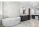 An open-concept bathroom with modern soaking tub and sleek double vanity sinks with granite countertops at 196 Mountaintop Cir, Pittsboro, NC 27312