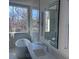 Contemporary bathroom with a soaking tub, marble countertops, a crystal trimmed mirror, and scenic outdoor views at 196 Mountaintop Cir, Pittsboro, NC 27312