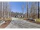 Long driveway leading up to a modern home, surrounded by mature trees and manicured landscaping at 196 Mountaintop Cir, Pittsboro, NC 27312