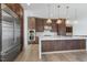 Modern kitchen featuring stainless steel appliances, quartz countertops, custom cabinets, and stylish pendant lighting at 196 Mountaintop Cir, Pittsboro, NC 27312