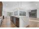 Bright kitchen with large island, stainless appliances and view of the living room fireplace and floor to ceiling windows at 196 Mountaintop Cir, Pittsboro, NC 27312