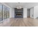 Spacious living room with hardwood floors, modern fireplace, large sliding glass doors, and contemporary lighting fixture at 196 Mountaintop Cir, Pittsboro, NC 27312