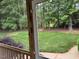 View from the screened porch of the backyard featuring mature trees and lush green grass at 2012 Silverleaf Dr, Youngsville, NC 27596