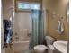 Bright bathroom featuring a shower with blue curtain and a single sink vanity with large round mirror at 2012 Silverleaf Dr, Youngsville, NC 27596
