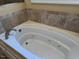 Close-up of a modern soaking tub with tile surround at 2012 Silverleaf Dr, Youngsville, NC 27596