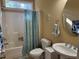 Bright bathroom featuring a shower with blue curtain and a single sink vanity with large round mirror at 2012 Silverleaf Dr, Youngsville, NC 27596