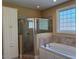 Bathroom featuring a walk-in shower, soaking tub, and white cabinets at 2012 Silverleaf Dr, Youngsville, NC 27596